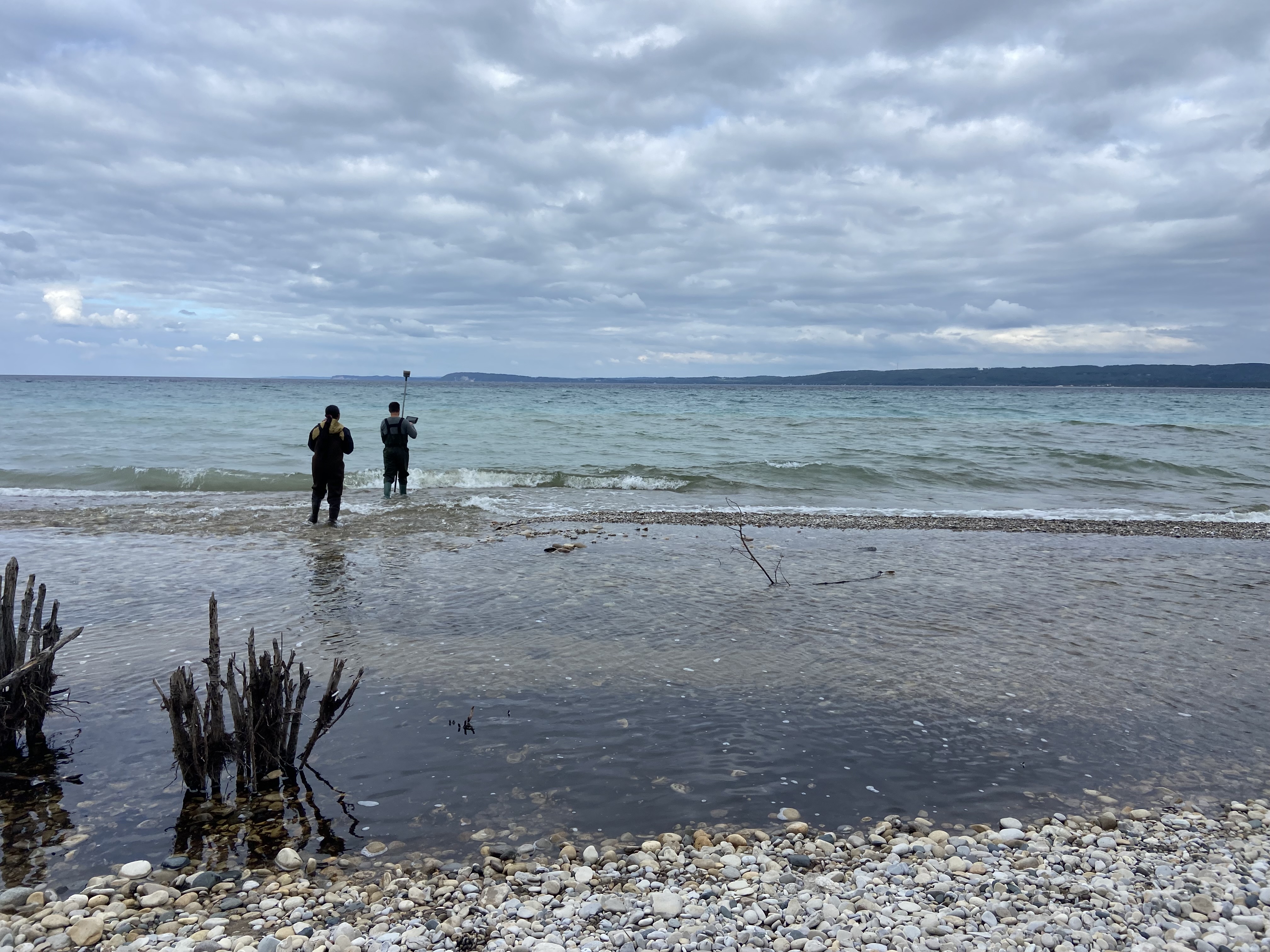 2 people standing in the distance on a beach