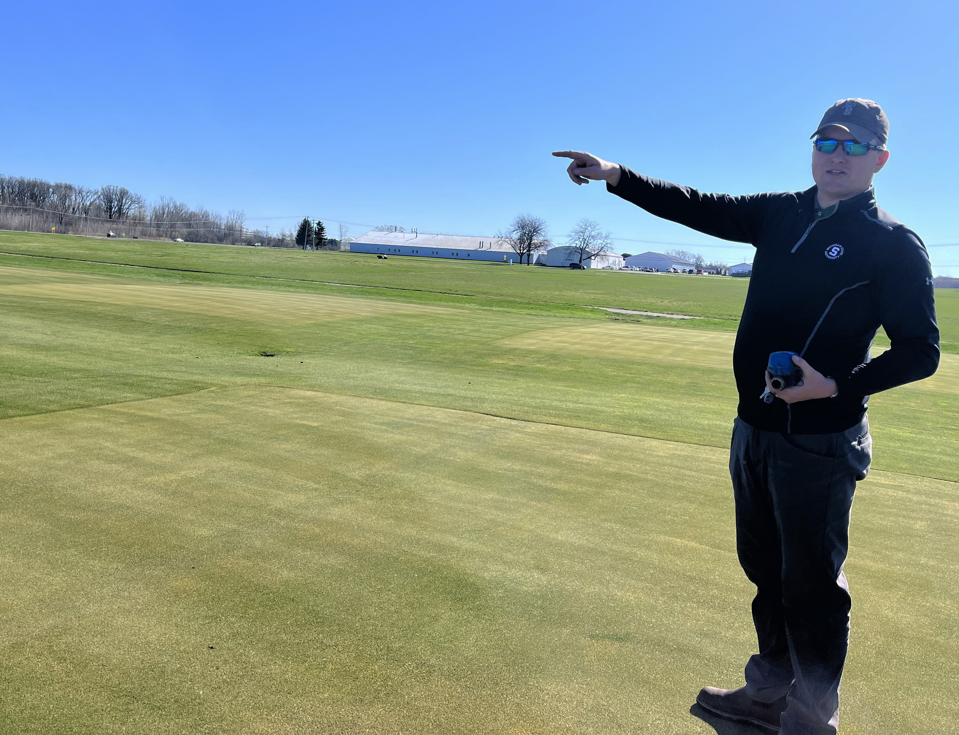 A man points out at a golfing green