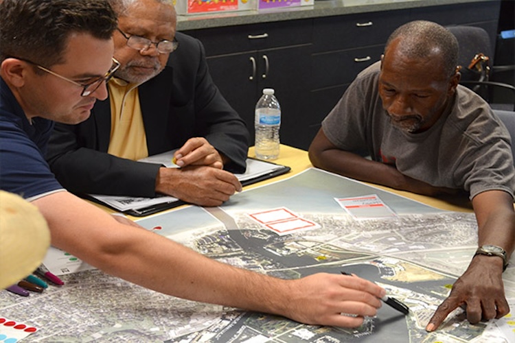 Three people analyzing a map