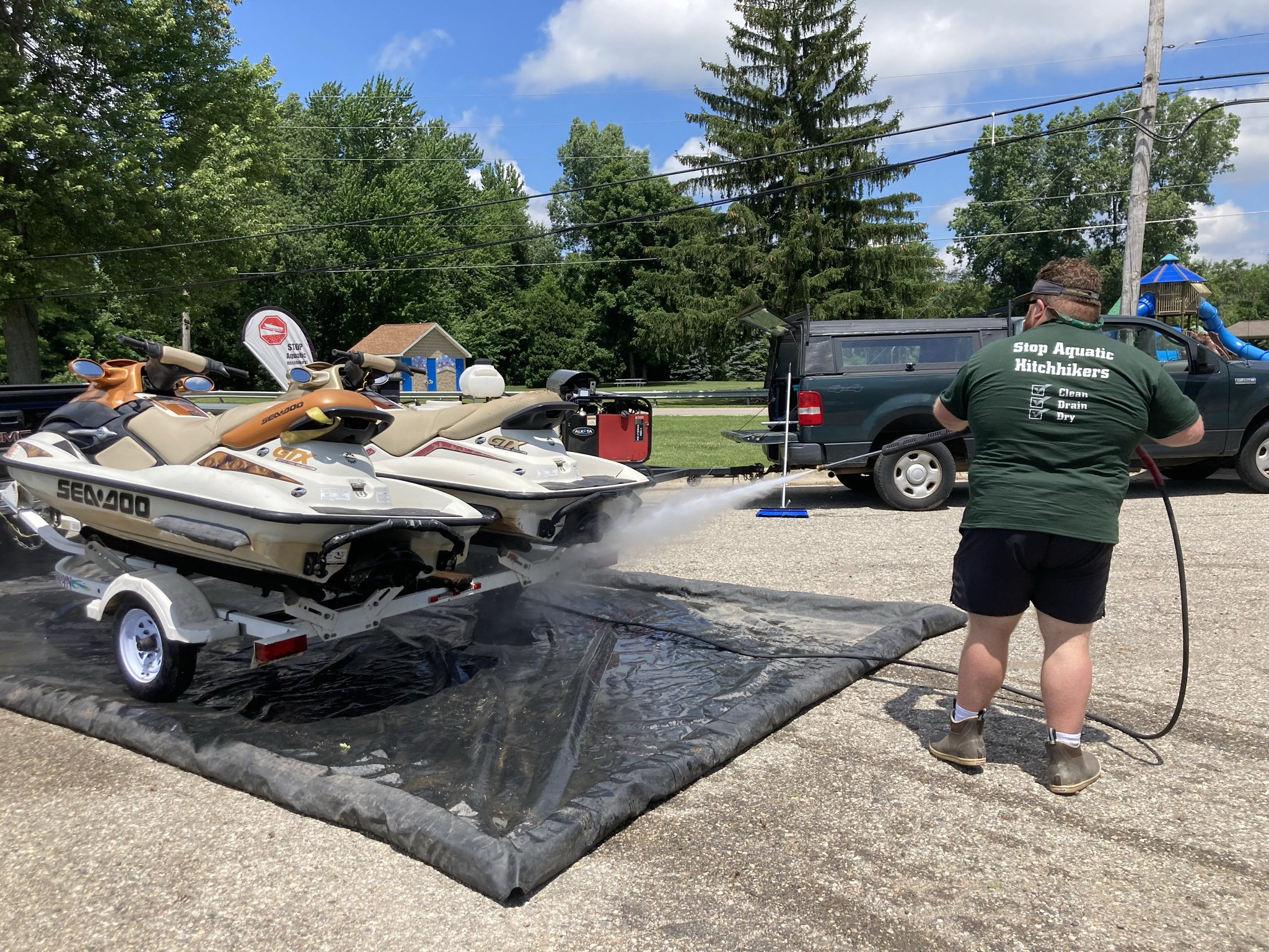 A person washing a boat with a hose