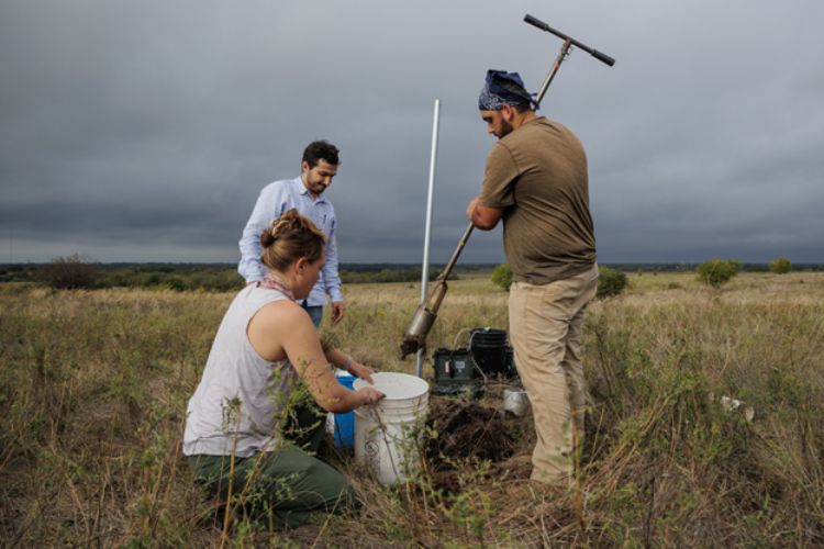 three IWR scientists conducting fieldwork in a rangeland.