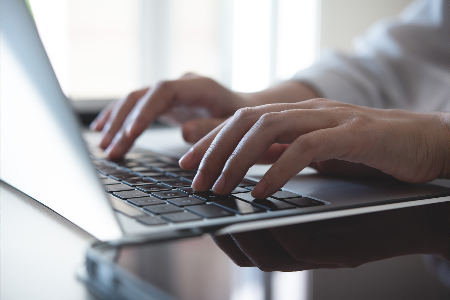 Hands Typing on a Laptop