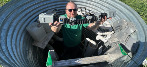 Researcher holding robot in a drainage pipe.