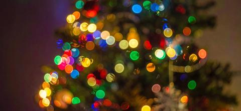 Out of focus colorful holiday lights create a soft glowing background.