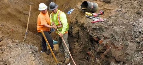 Two workers replace a lead line in Jackson.